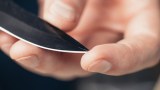 ein Messer wird in einer Hand gehalten, ein Finger drückt auf die Messerspitze