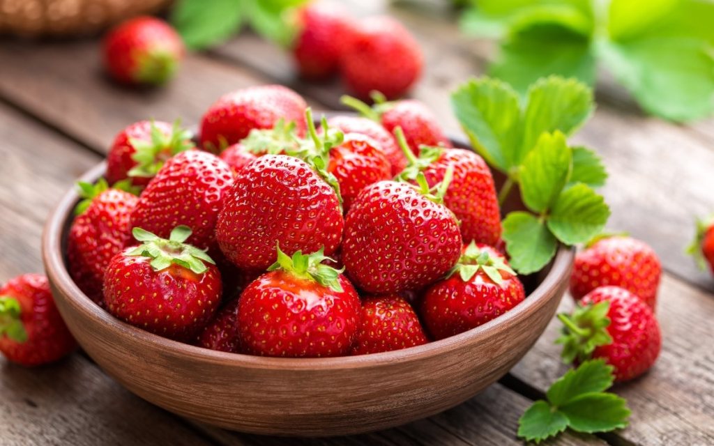 Eine Schale Erdbeeren steht auf dem Tisch.