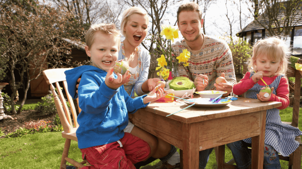 Familienfest, junge Familie beim Eier bemalen im Garten