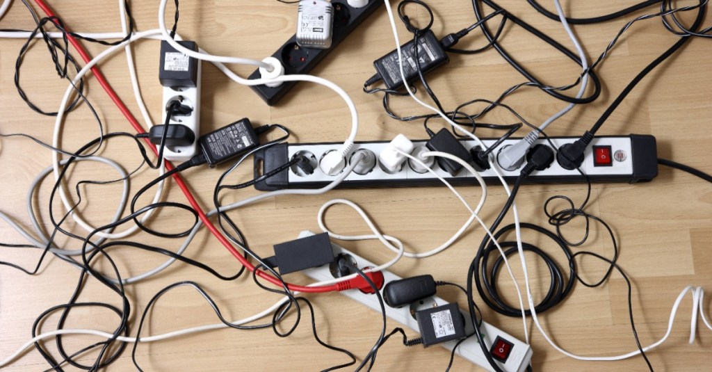Kabel verstecken: Mehrfachsteckdosen und zahlreiche Kabel liegen auf dem Fußboden