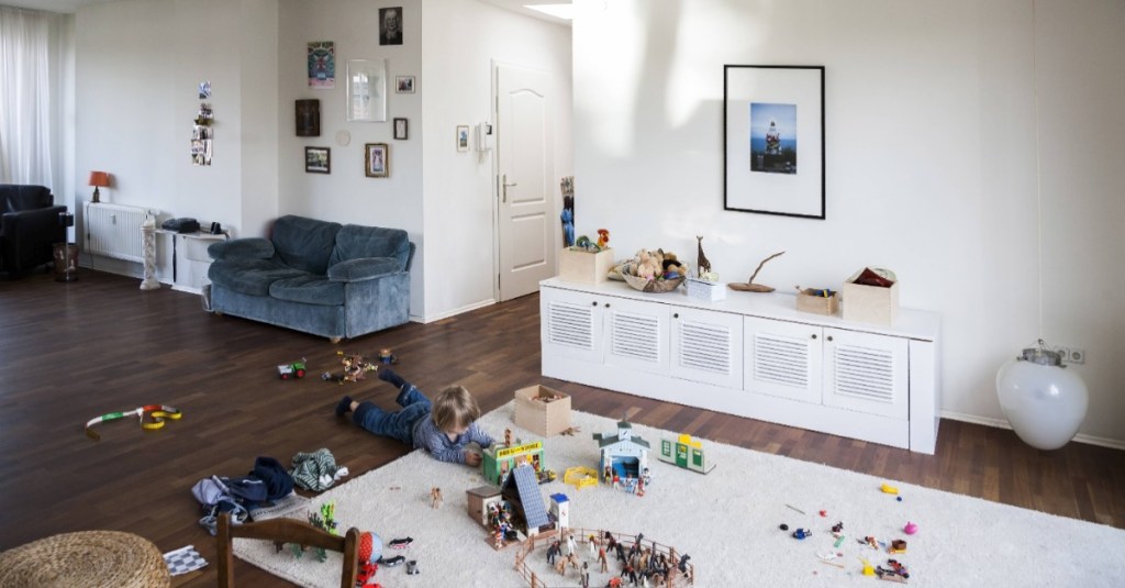 Stauraum Wohnzimmer: ein kleiner Junge spielt auf dem Boden im Wohnzimmer