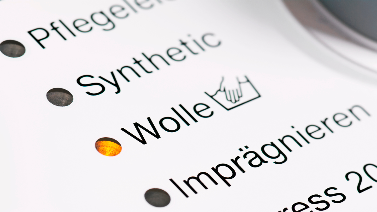 Auf einer Waschmaschine sieht man verschiedene Programme, unter anderem das für Wolle.