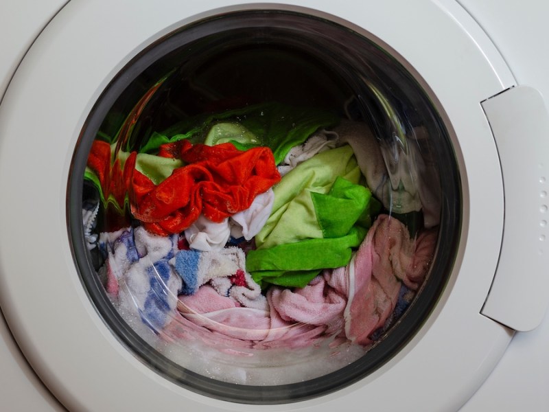 Neue Kleidung wird in der Waschmaschine gewaschen.