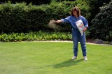 Eine Frau beim Rasen kalken in einem Garten.