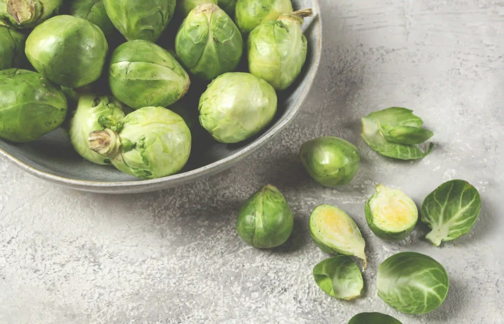 Frischer Rosenkohl, roh, Ansicht von oben, auf einem grauen Tisch
