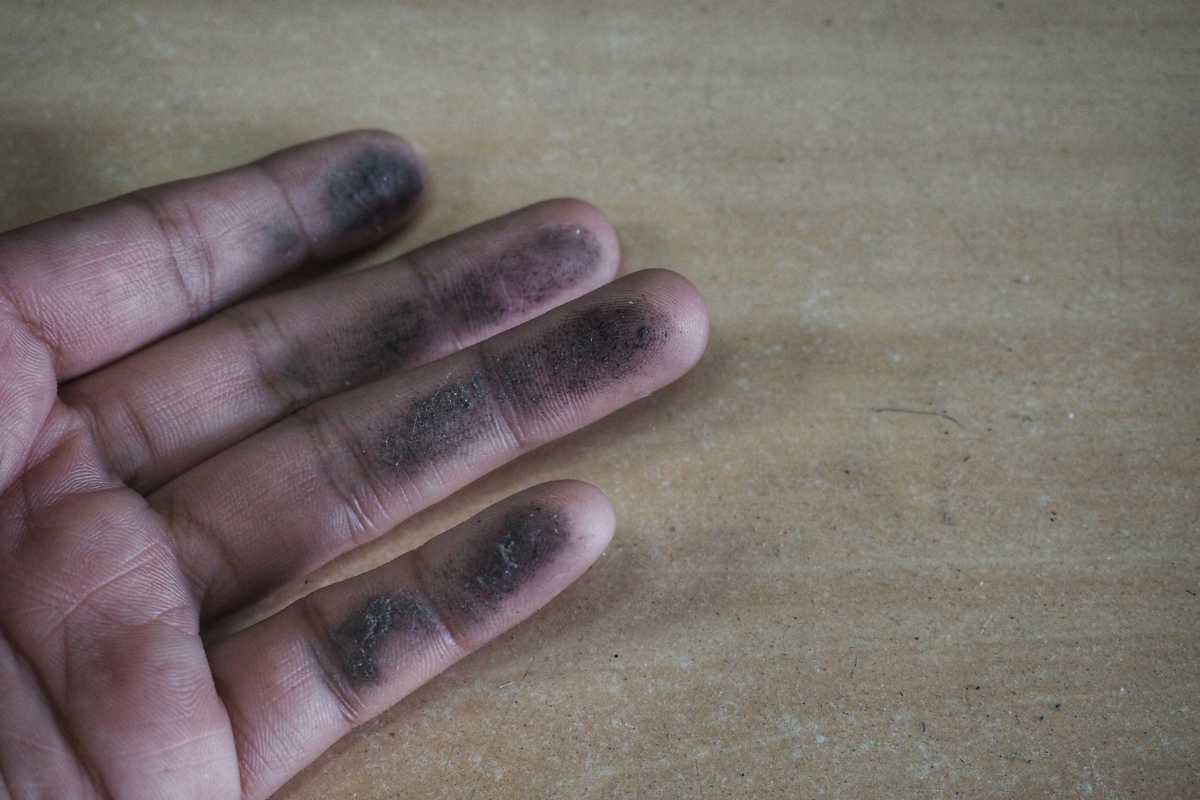 Eine Hand mit Rußflecken darauf.