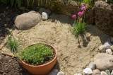 Ein Bild von einem Sandarium in einem Garten.