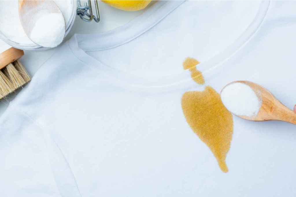 Ein T-Shirt mit einem gelben Fleck auf dem weißen Stoff.