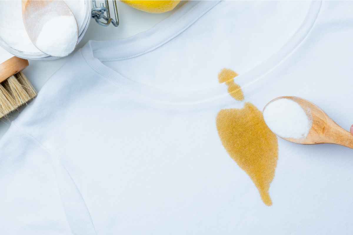 Ein T-Shirt mit einem gelben Fleck auf dem weißen Stoff.