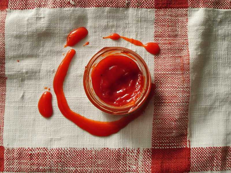Eine Schale Tomatensoße steht auf einem Geschirrtuch.