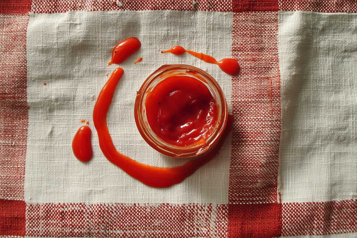 Eine Schale Tomatensoße steht auf einem Geschirrtuch.