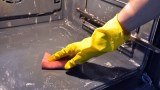 Backofen reinigen mit einem Handschuh und Lappen