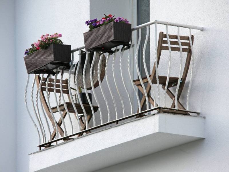 Ein schmaler Balkon mit Balkonmöbeln.