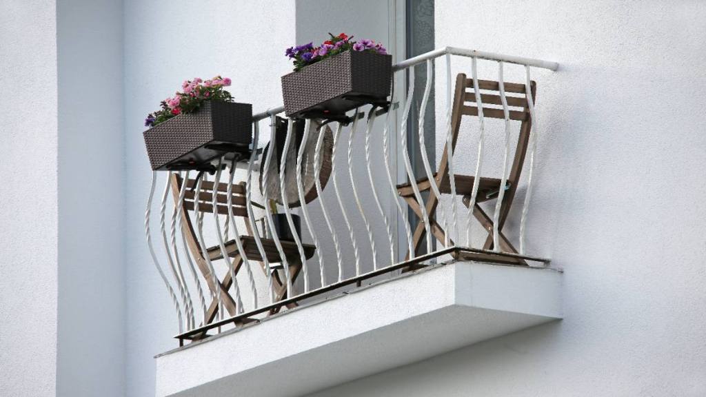 Ein schmaler Balkon mit Balkonmöbeln.