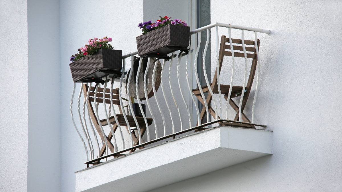 Ein schmaler Balkon mit Balkonmöbeln.