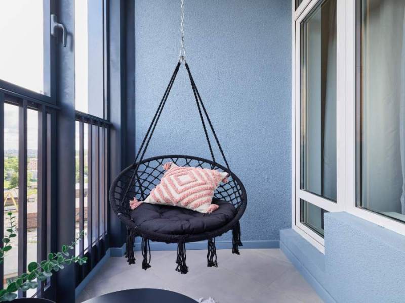 Ein Hängesessel auf einem Balkon.