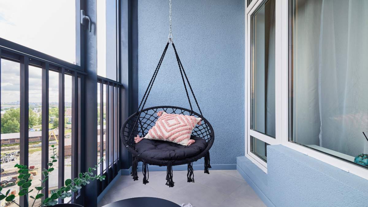 Ein Hängesessel auf einem Balkon.