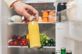 Eine Flasche Saft wird zum Einfrieren in einen Kühlschrank gegeben.