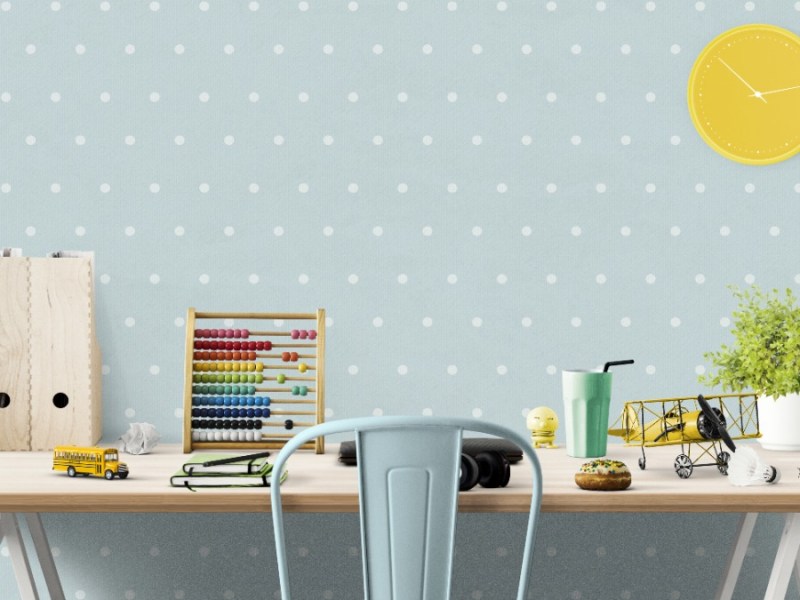 ein Kinderzimmerschreibtisch vor einer hellblauen Wand