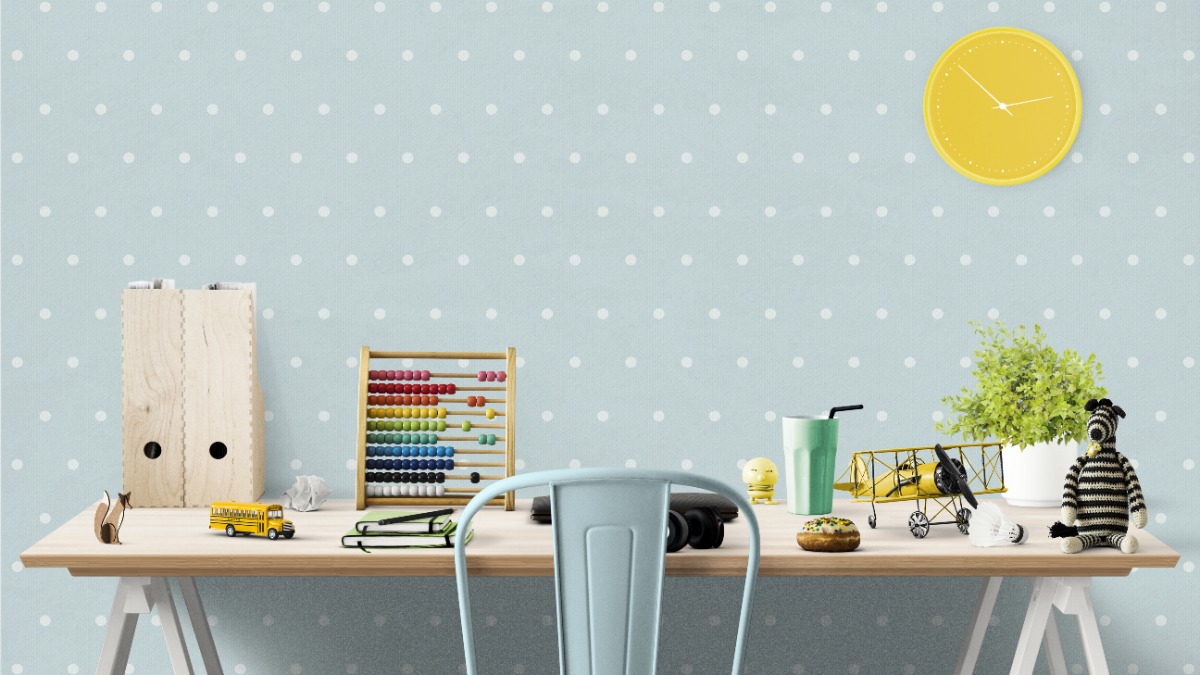ein Kinderzimmerschreibtisch vor einer hellblauen Wand