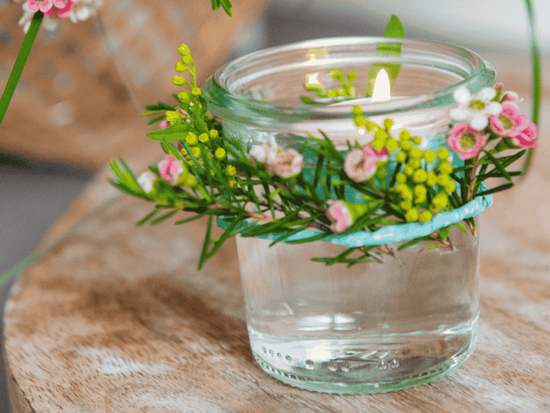 Tischdeko Muttertag, kleines Glas mit Schwimmkerze und Blütenkranz
