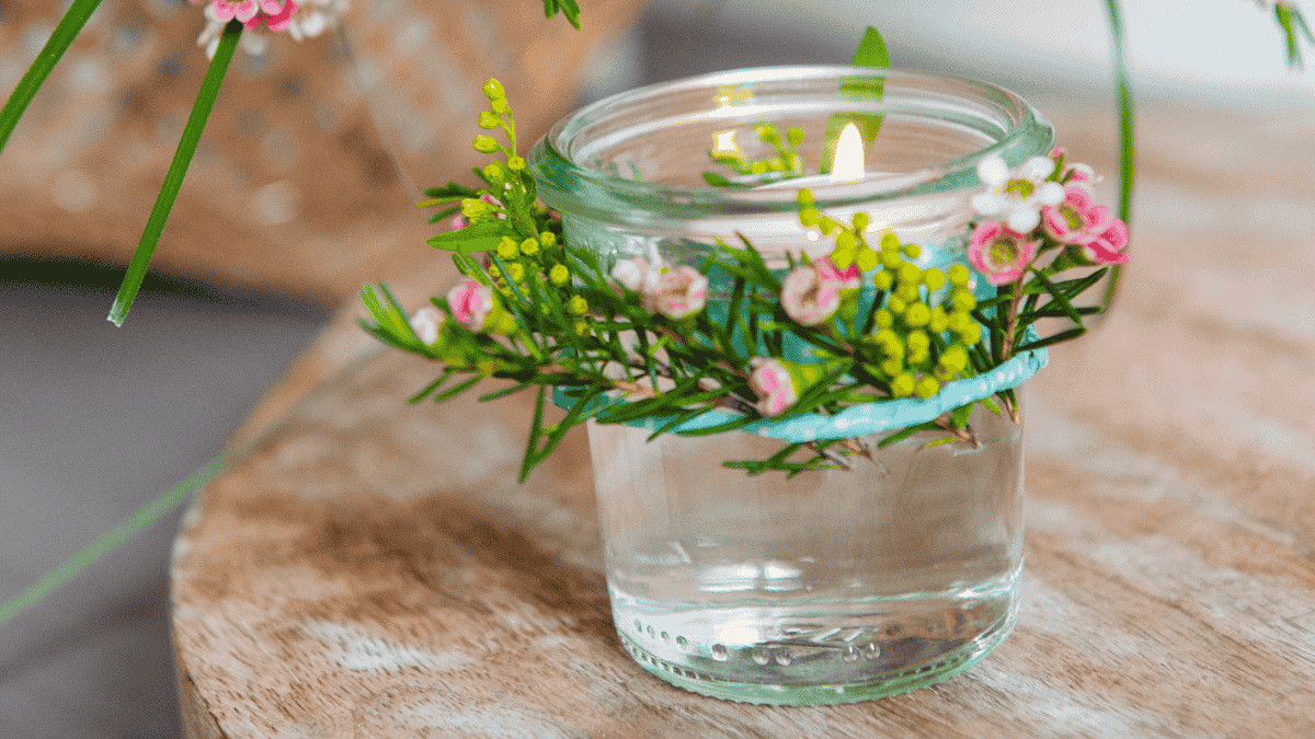 Tischdeko Muttertag, kleines Glas mit Schwimmkerze und Blütenkranz