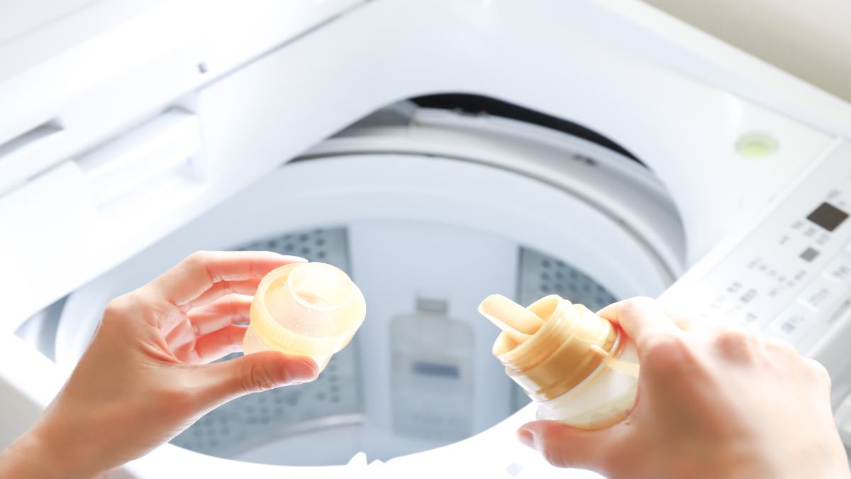 Ein Weichspüler wird in eine Waschmaschine geschüttet.
