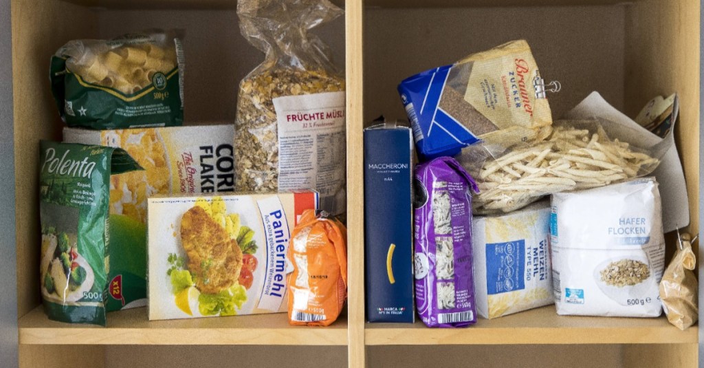 Vorratsschrank organisieren: verschiedene Lebensmittel liegen wahllos in einem Schrank