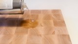 Auftragen von Holzpflegeöl auf ein Holzschneidebrett