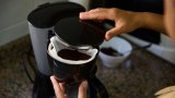 jemand bereitet Kaffee in einer Filterkaffeemaschine zu