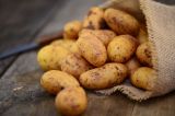 Ein Sack Kartoffeln liegt auf dem Tisch.