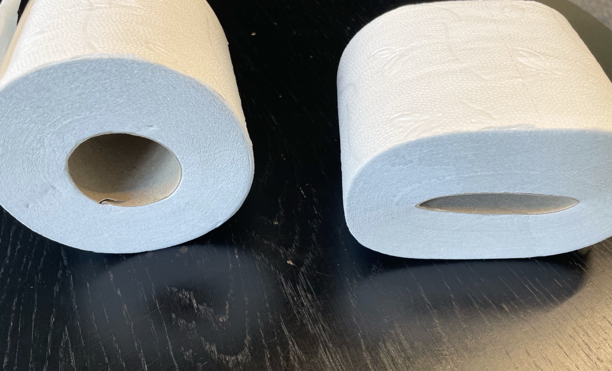 Zwei Rollen Klopapier liegen nebeinander auf einem Tisch.