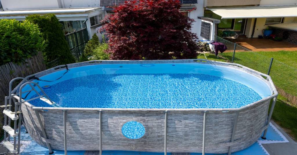 Ein Pool aus Plastik in einem Garten.