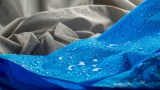 Eine blaue Regenjacke wird gewaschen.