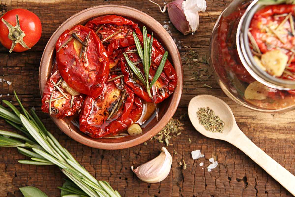 Eine Schüssel mit getrockneten Tomaten und Olivenöl steht auf einem Tisch.
