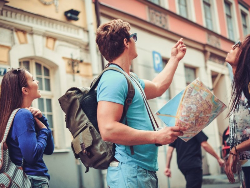 Tourist mit einer Stadtkarte in einer Altstadt.