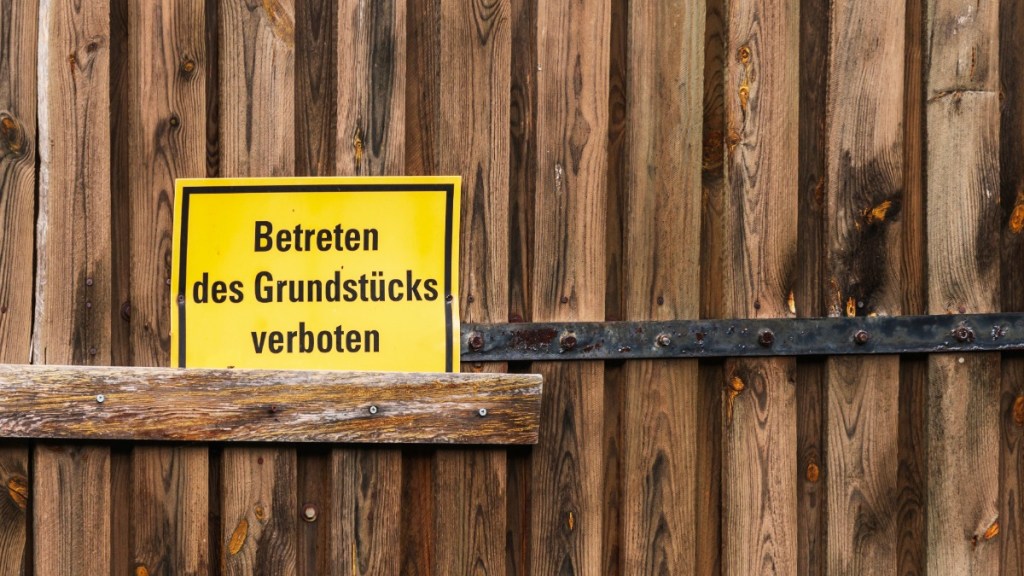 ein "Betreten verboten"-Schild vor einer Holzwand
