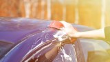 ein blaues Auto wird in der Sonne gewaschen