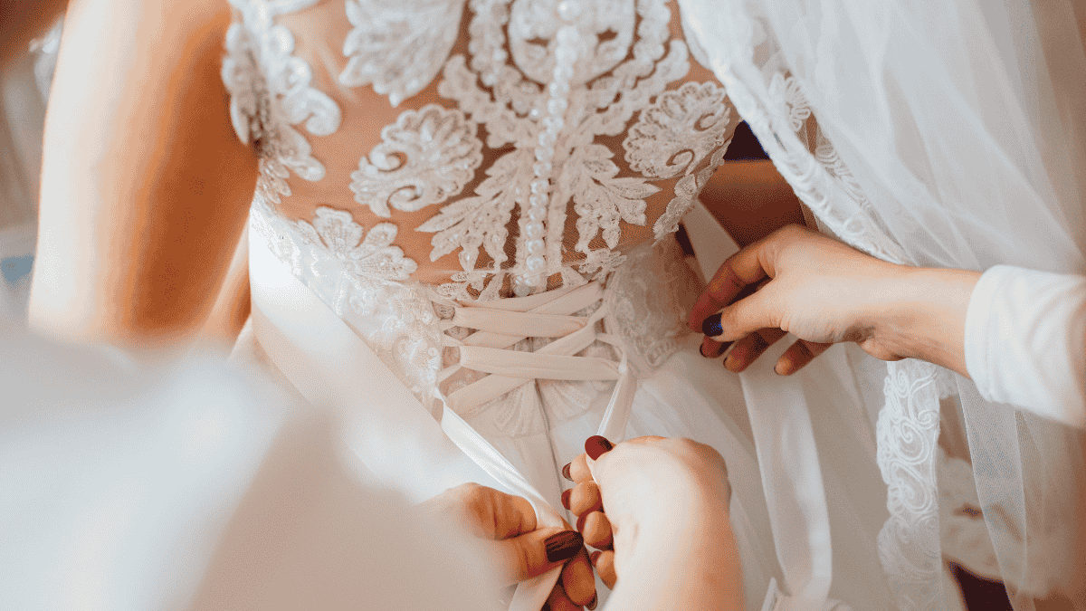 Getting ready Hochzeit, Brautkleid wird zugebunden