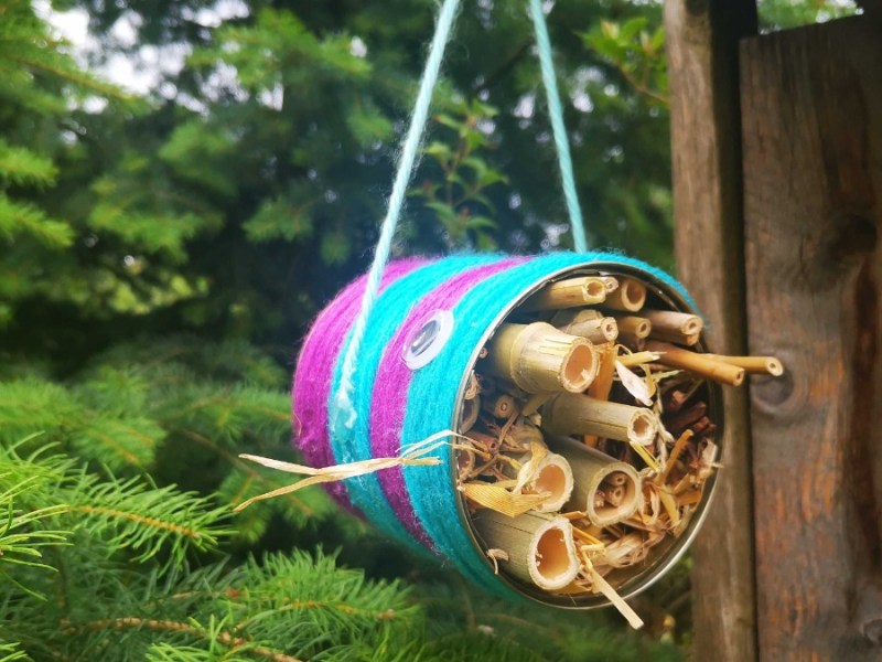 ein selbst gebautes Insektenhotel hängt in einem Garten