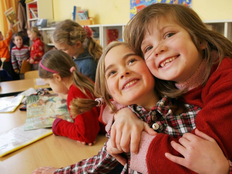 Zwei Schulkinder, die sich umarmen