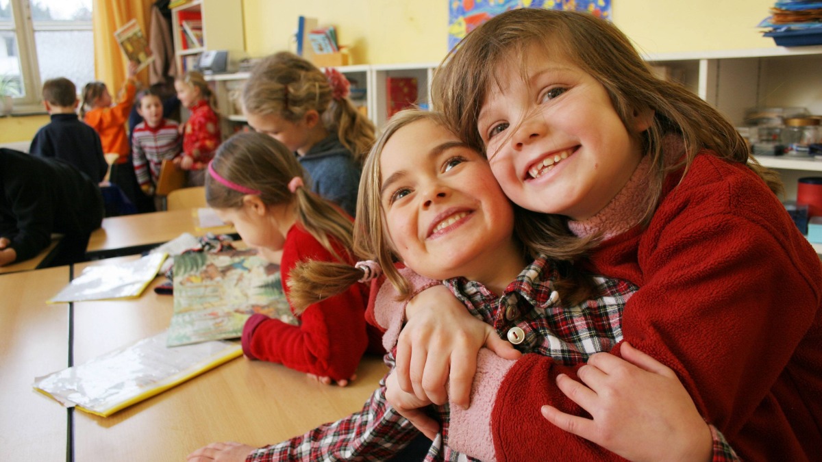 Zwei Schulkinder, die sich umarmen