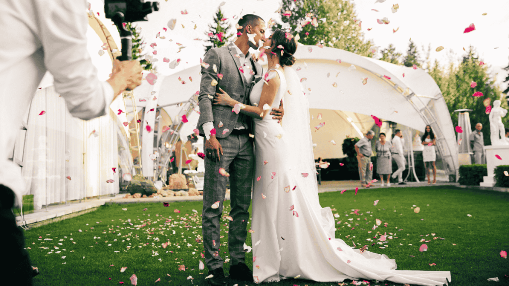 Paarshooting Hochzeit, Fotograf macht gerade ein Foto vom Brautpaar auf das währenddessen Konfetti fällt