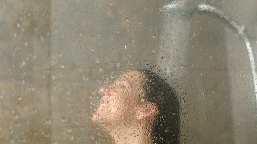 ein Frau steht unter der Dusche