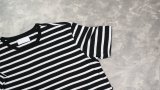 Ein schwarz-weißes T-Shirt liegt auf dem Boden.