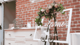 Willkommensschild Hochzeit, weißer Rahmen mit Glasscheibe und Blumendeko