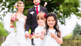 Hochzeit mit Kindern, Mädchen streuen Blumen vor Brautpaar