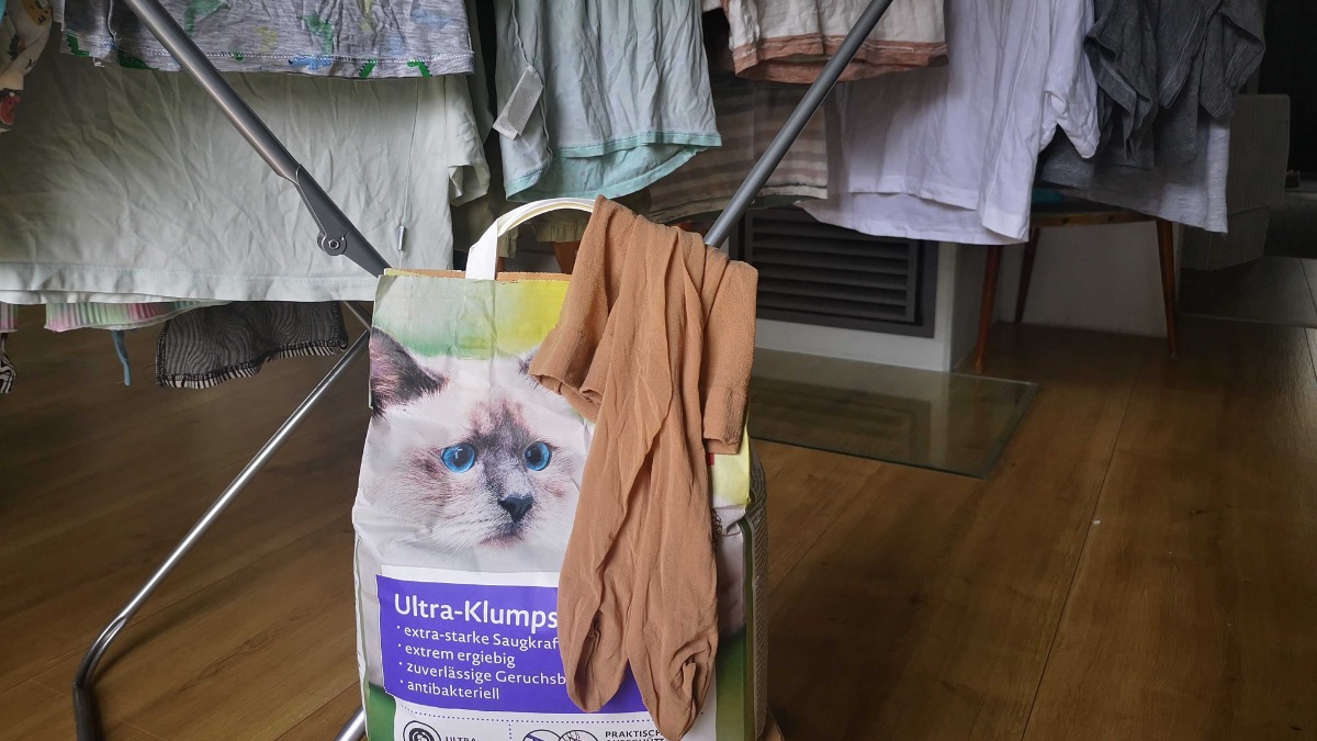 eine Nylonstrumpfhose liegt auf einem Paket Katzenstreu
